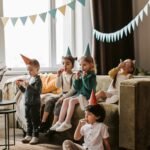 Renginio vedėjas linksmina svečius jaukaus gimtadienio šventės namuose metu.